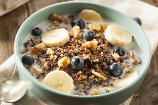 A bowl of muesli with banana slices and blueberries