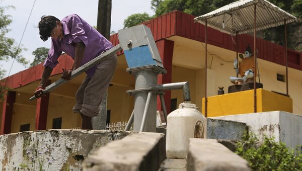 Местный житель набирает воду из источника в Котле, Индия