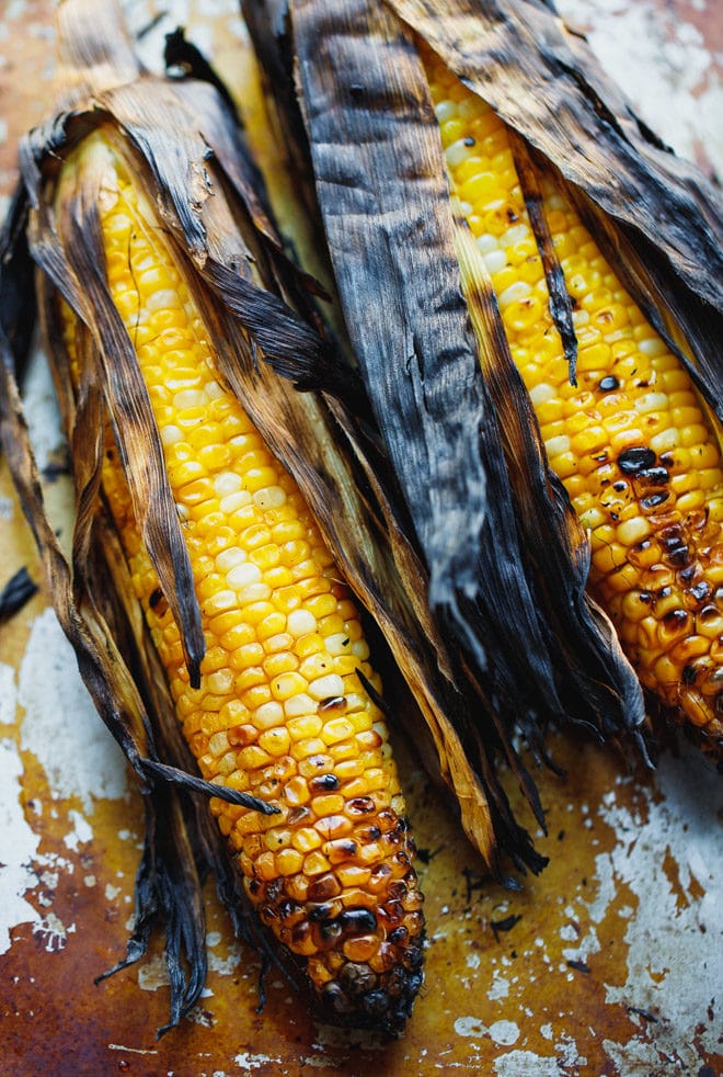Ears of corn on te cob grilled with the husk on