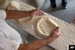 Bakers prepare the dough with ingredients provided by families to prepare and bake special pitta bread called in Albanian (pitalka) for Iftar during the holy month of Ramadan in southern Kosovo city of Prizren on Friday, June 17, 2016. (AP Photo)