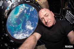 NASA astronaut Scott Kelly inside the cupola of the International Space Station, an area that provides a 360-degree viewing of the Earth and the station.