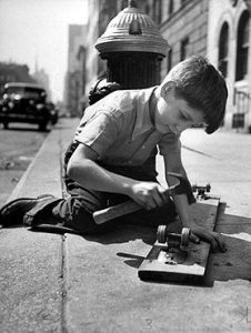A young boy working on his skateboard in the street