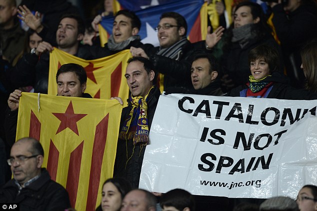 Clear message: Catalonia supporters hold up banners and flags during the match
