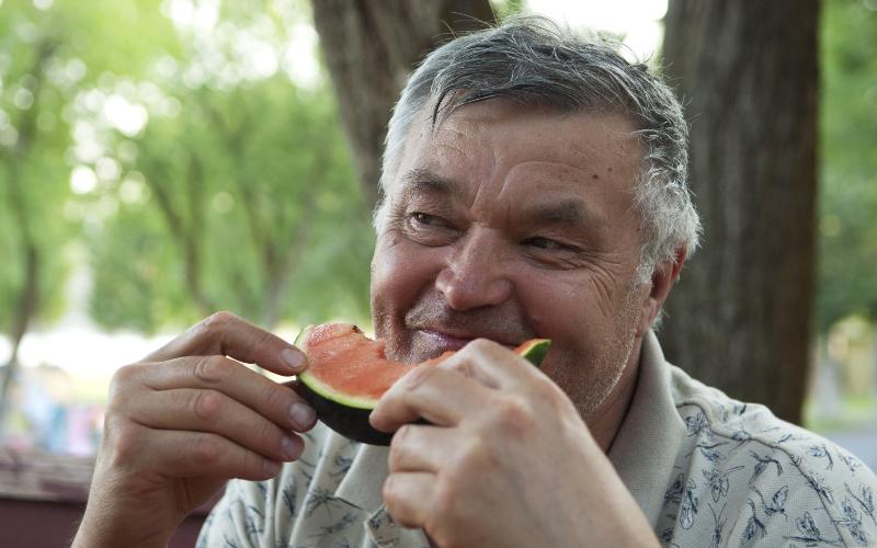 senior man eating watermelon