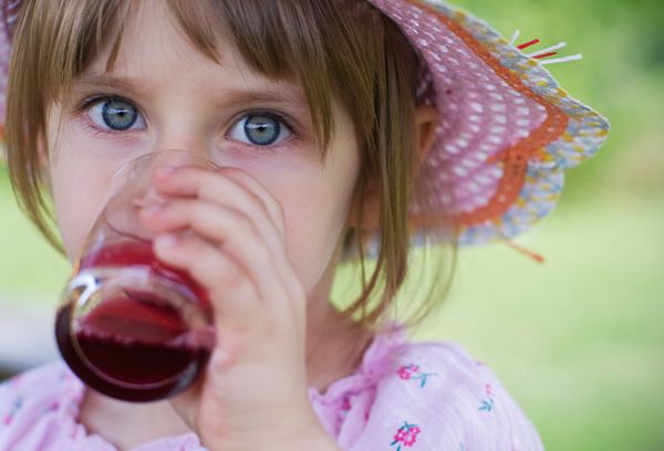 Девочка пьет виноградный сок