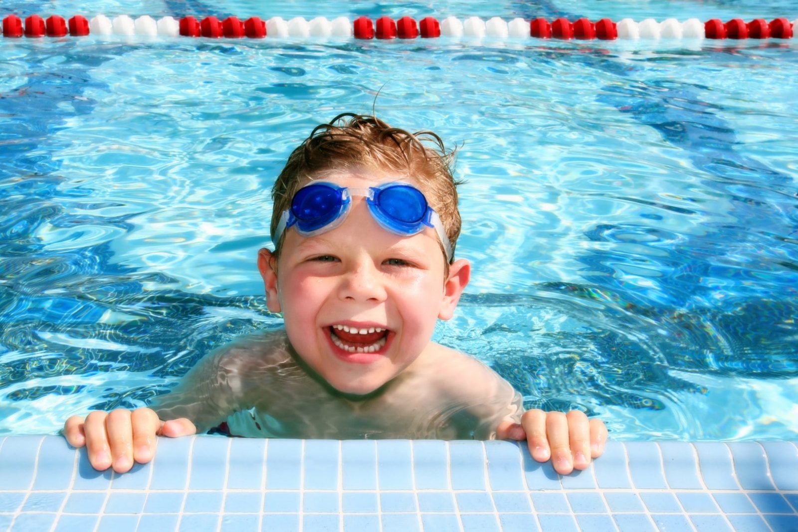 Маленький ребенок в плавательных очках в бассейне