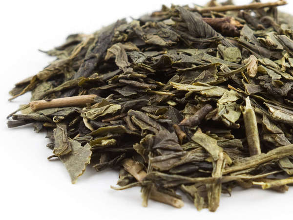 Loose-leaf green tea with dark green, flat leaves, slightly broken, and a few stems
