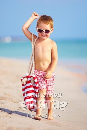 Мальчик с сумкой гуляет по пляжу, фото