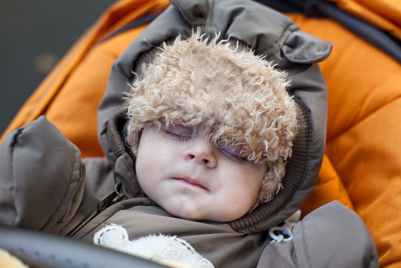 Baby boy toddler sleeping in orange pram royalty free stock images
