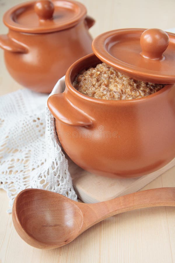 Barley porridge, baked with milk. In a ceramic pot royalty free stock photography