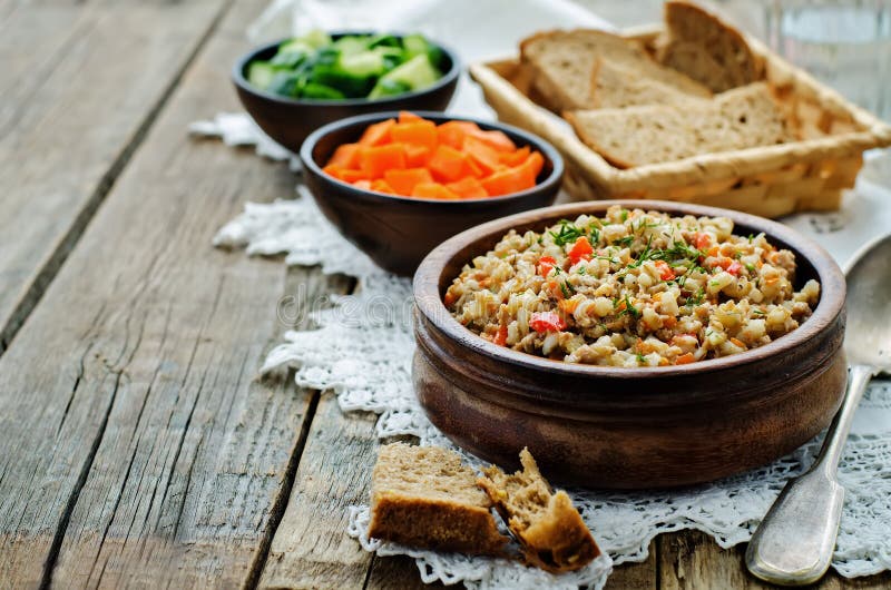 Barley porridge with meat and vegetables. On a dark wood background. tinting. selective focus stock image