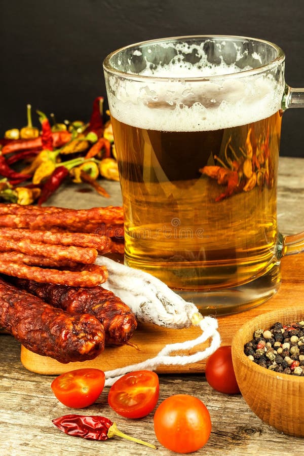Beer and sausages on an old wooden table. Sale of beer and sausage. Food for beer. Unhealthy food.  royalty free stock photography