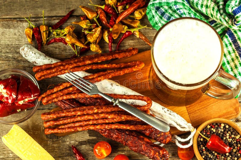 Beer and sausages on an old wooden table. Sale of beer and sausage. Food for beer. Unhealthy food.  royalty free stock photo