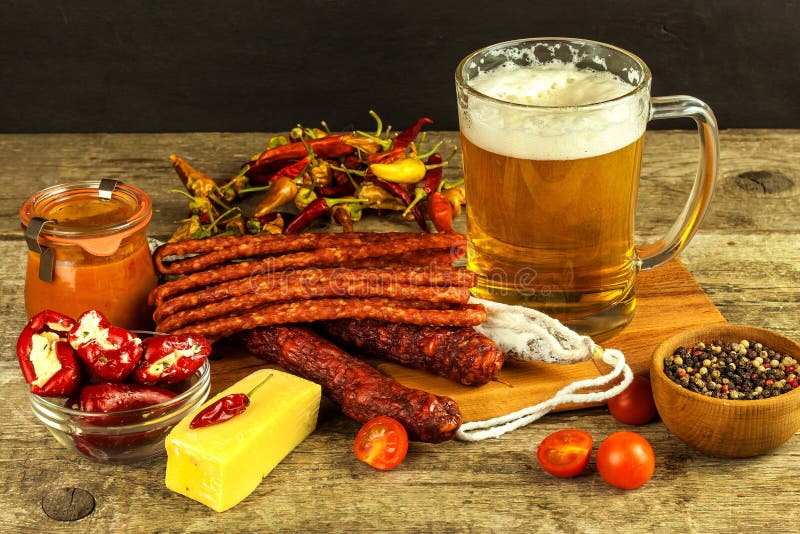 Beer and sausages on an old wooden table. Sale of beer and sausage. Food for beer. Unhealthy food.  royalty free stock image