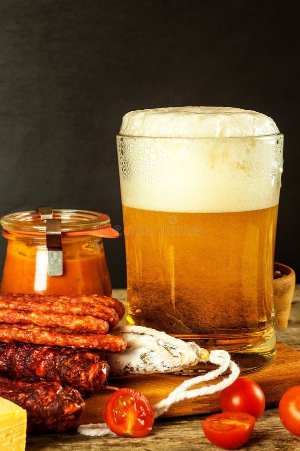 Beer and sausages on an old wooden table. Sale of beer and sausage. Food for beer. Unhealthy food.  stock images