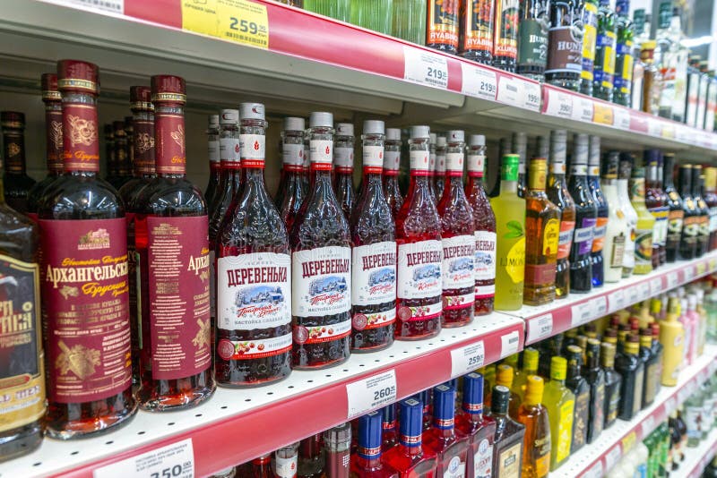 Bottles of berry sweet tincture stand on a shelf in a supermarket. Close-up. Russia Samara January 2020: Bottles of berry sweet tincture stand on a shelf in a stock photos