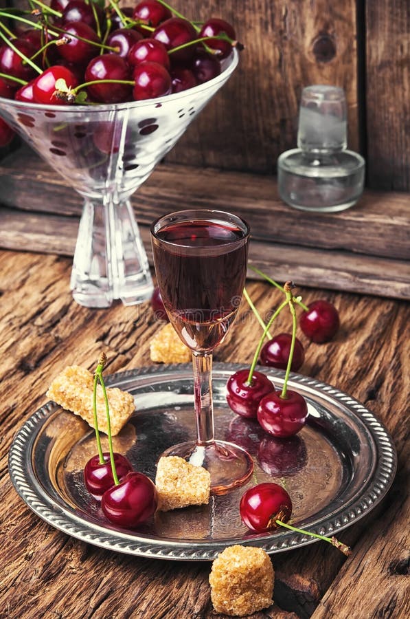 Cherry alcohol drink. Homemade alcohol tincture from summer cherry berries stock images