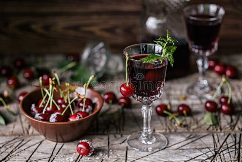 Cherry tincture. In a glass on the background of a rustic table stock images