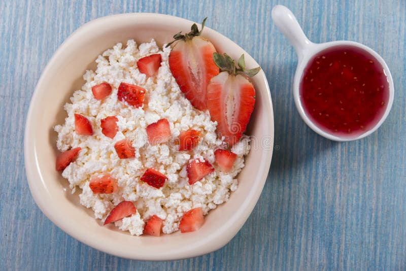 Cottage cheese grainy crumbly with pieces of strawberries jam royalty free stock images