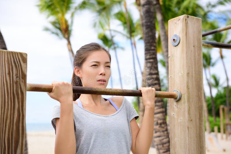 Fitness woman exercising on chin-up bar royalty free stock images