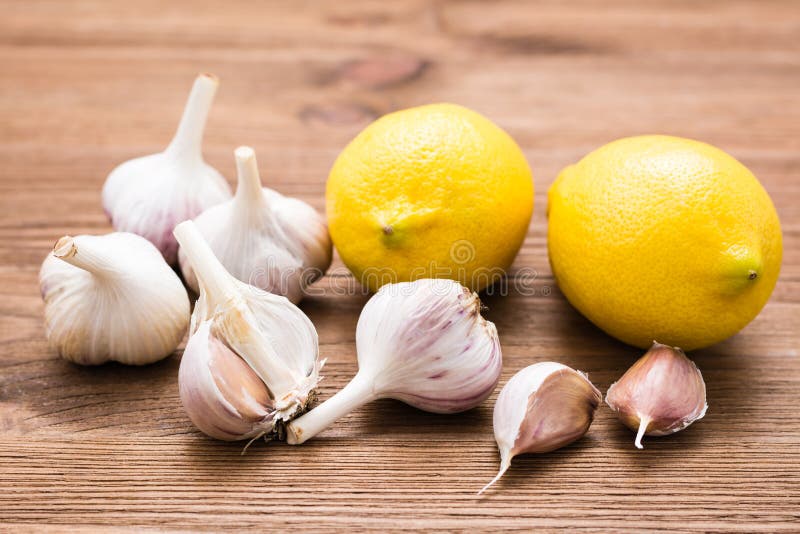 Garlic and lemon on a wooden table. Alternative medicine, treatment with folk remedies. Lower cholesterol royalty free stock photography