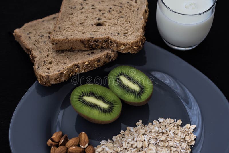 Healthy breakfast with bread, oatmeal, kiwi and milk for athletes stock photography