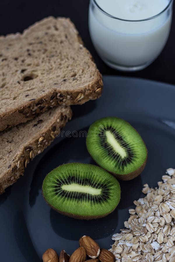 Healthy breakfast with bread, oatmeal, kiwi and milk for athletes royalty free stock photo