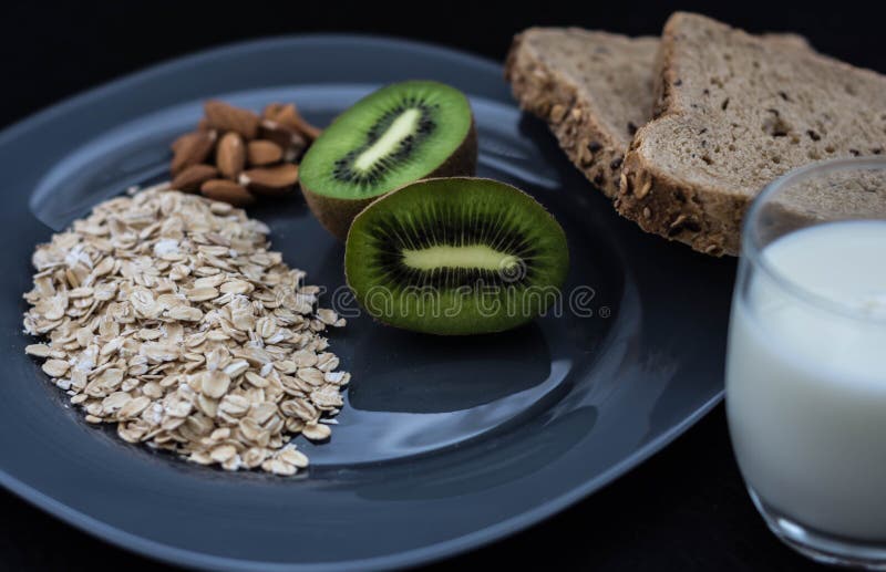 Healthy breakfast with bread, oatmeal, kiwi and milk for athletes stock photo