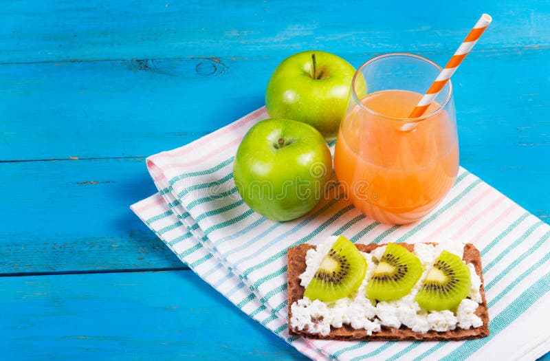 Healthy breakfast. A glass of freshly squeezed grapefruit juice, green apple and toast with cheese and kiwi slices. stock image