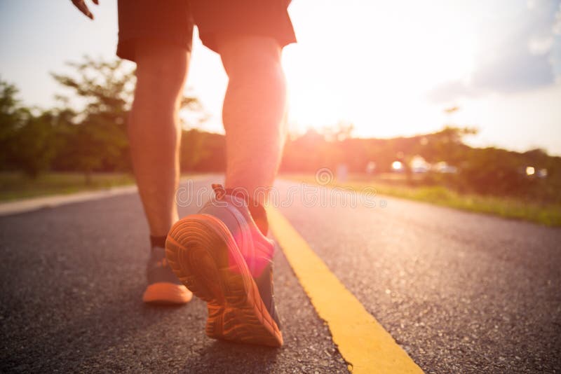 Healthy lifestyle sports a man legs running and walking. While exercising outdoors during sunrise or sunset. Moving forward to success concept stock photo