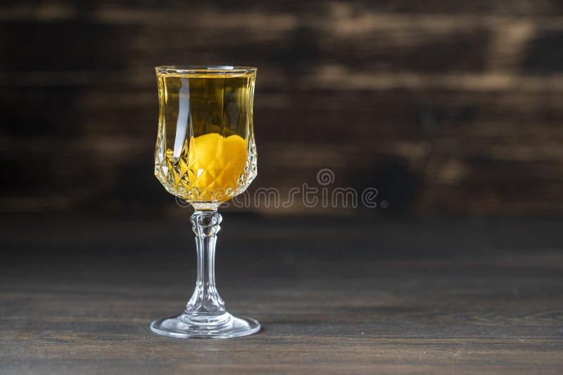 Homemade tincture of yellow cherry plum wine crystal glass on wooden background, Ukraine, close up. Homemade tincture of yellow cherry plum in wine crystal glass royalty free stock photo