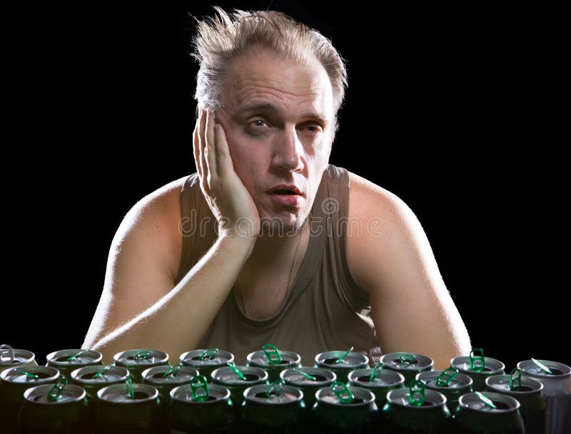 The man of an unhealthy kind after drunk the day b. Efore, before a heap of empty beer container royalty free stock image