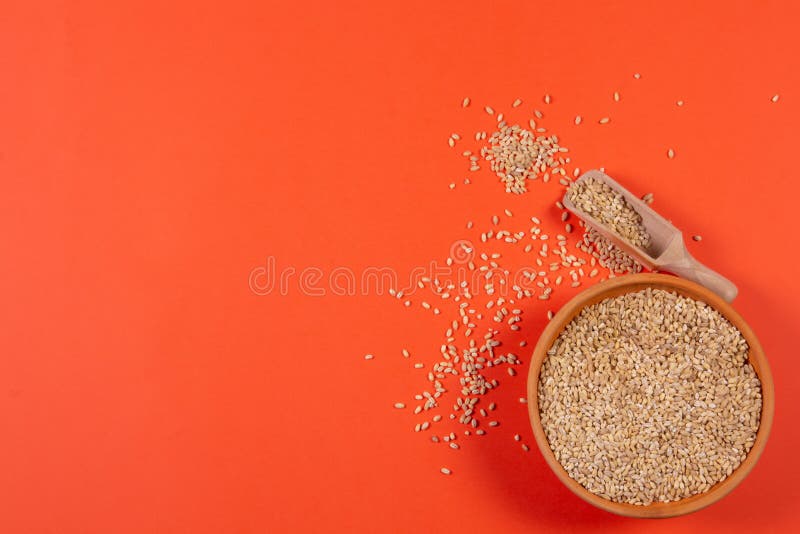 Pearl barley in a plate on a orange background stock image