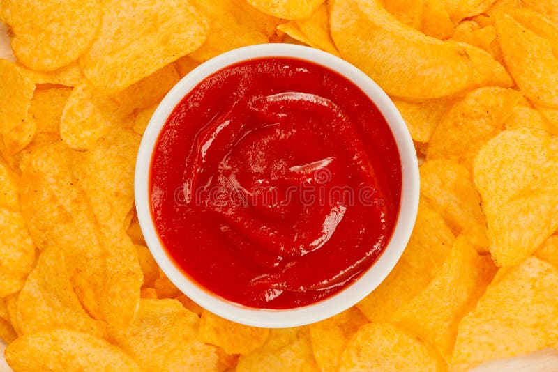 Potato chips and ketchup. Beer snack, unhealthy eating.  royalty free stock images