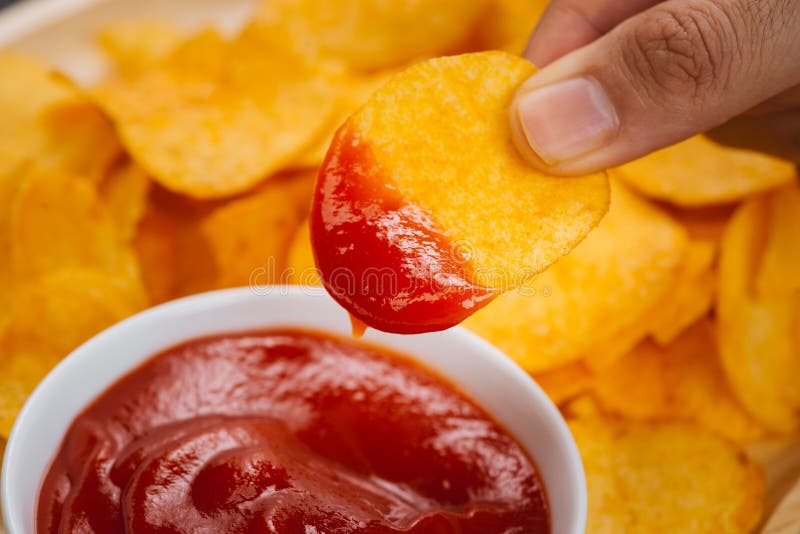 Potato chips and ketchup. Beer snack, unhealthy eating.  royalty free stock photography