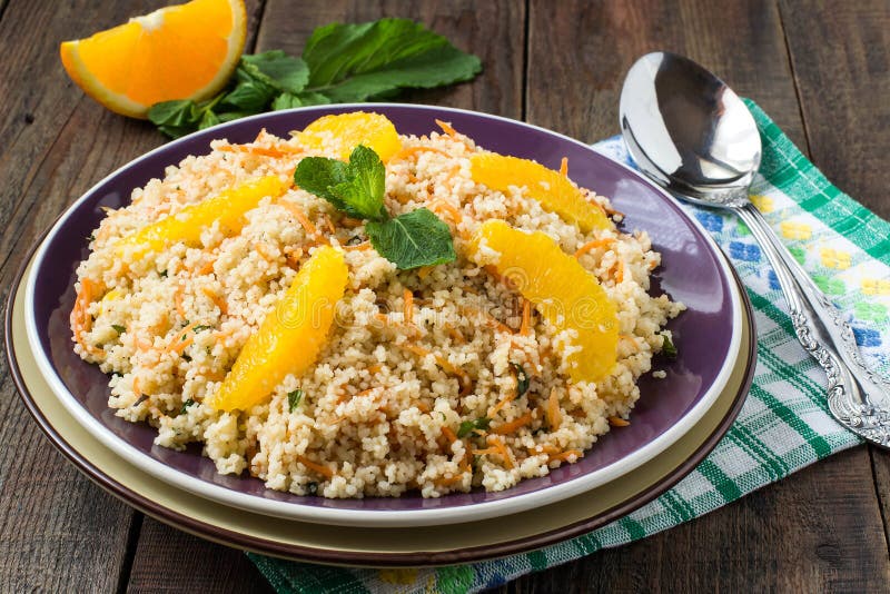 Salad of crumbly couscous with carrots, orange and mint stock photos
