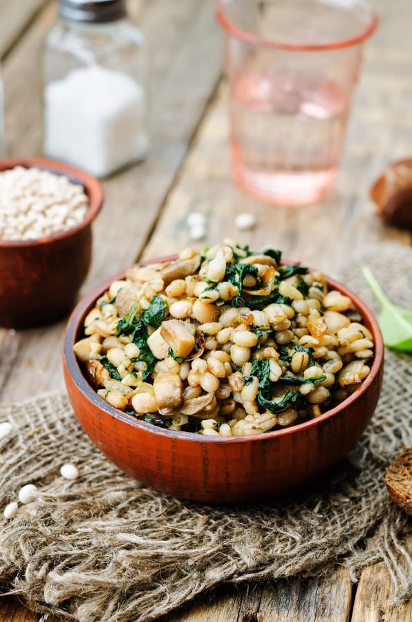 Spinach, white beans barley porridge. On a dark background. toning. selective Focus royalty free stock image