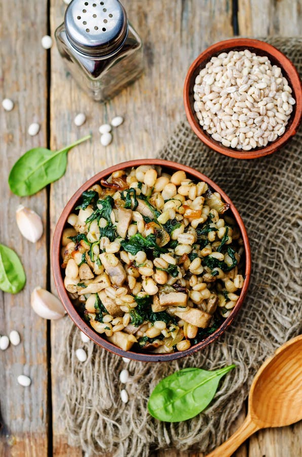 Spinach, white beans barley porridge. On a dark background. toning. selective Focus royalty free stock photo