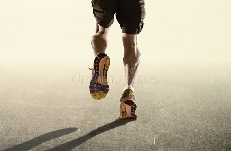 Strong legs and running shoes of sport man jogging in fitness healthy endurance concept in advertising style. Rear view close up strong athletic legs and running royalty free stock image