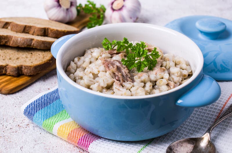 Traditional pearl barley porridge. With meat in a dish on the table. Selective focus stock photo