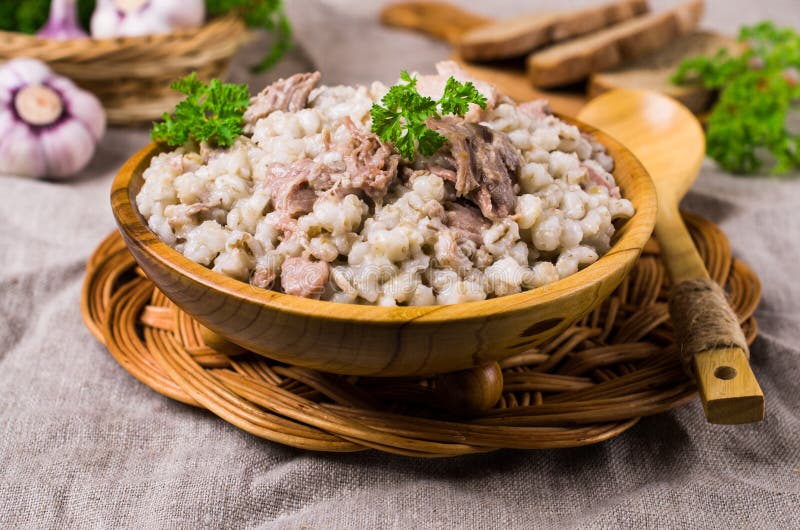 Traditional pearl barley porridge. With meat in a dish on the table. Selective focus royalty free stock image
