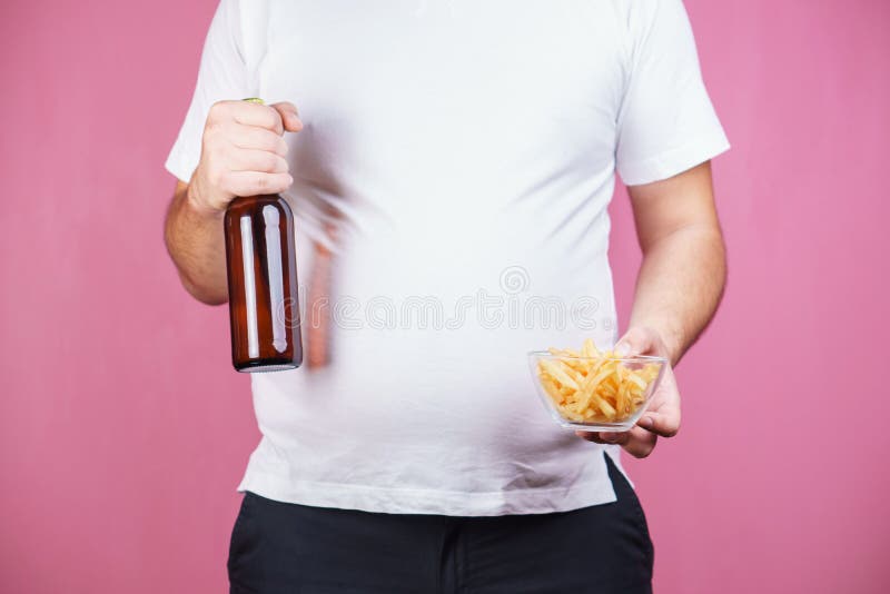 Unhealthy snack. fat man with beer and fast food. Unhealthy leisure, bad habits, overeating, eating fast food, pub snack. overweight. fat man with beer and royalty free stock photo