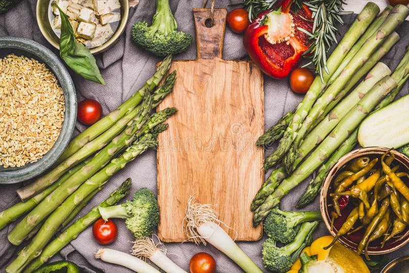 Vegetarian ingredients for pearl barley porridge or salad around wooden cutting board, top view. Healthy clean food stock images