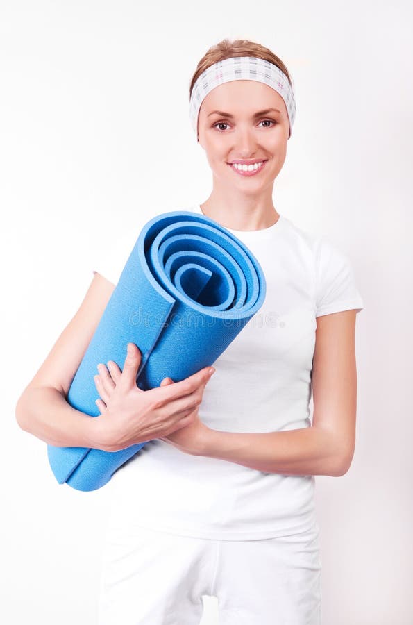 Woman with a rug. Beautiful young blond woman with a mat, going to work out stock images