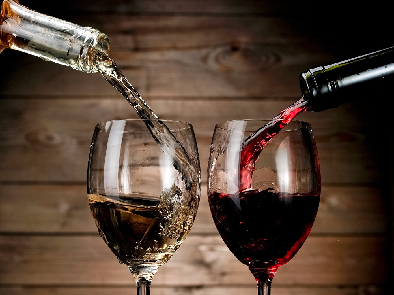 Фотография: в бокалы наливается из бутылок красное и белое вино