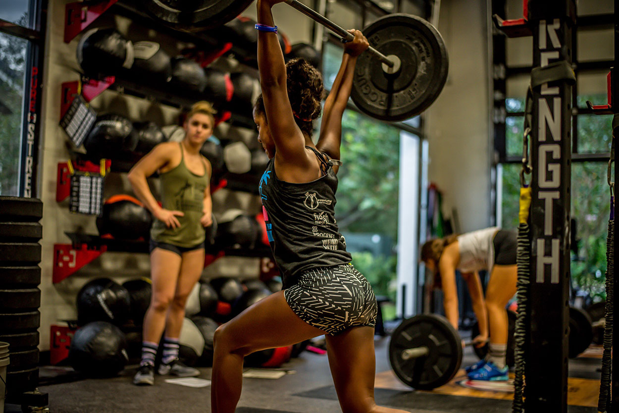 Woman Lifting a Barbell in the Gym.