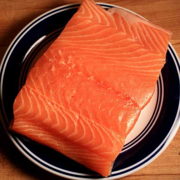 Raw Atlantic Salmon Fillet On Blue-Rimmed Dish