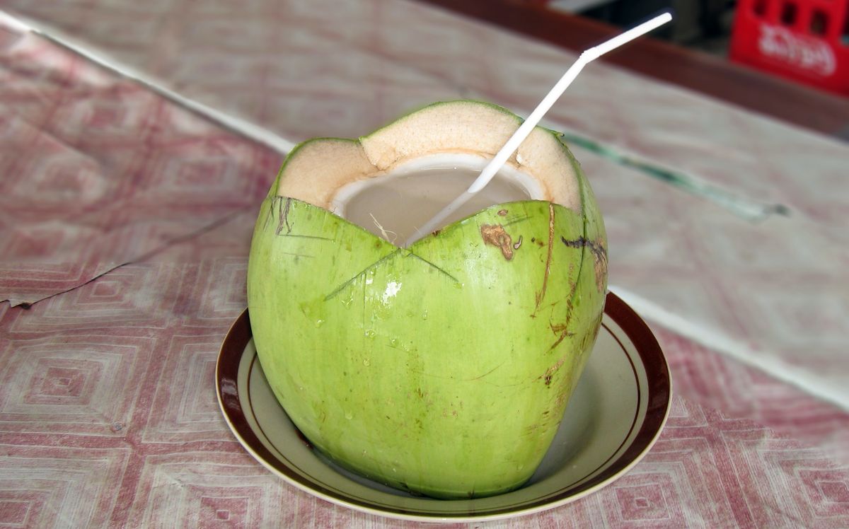 Открытый свежий кокос в котором видна прозрачная кокосовая вода