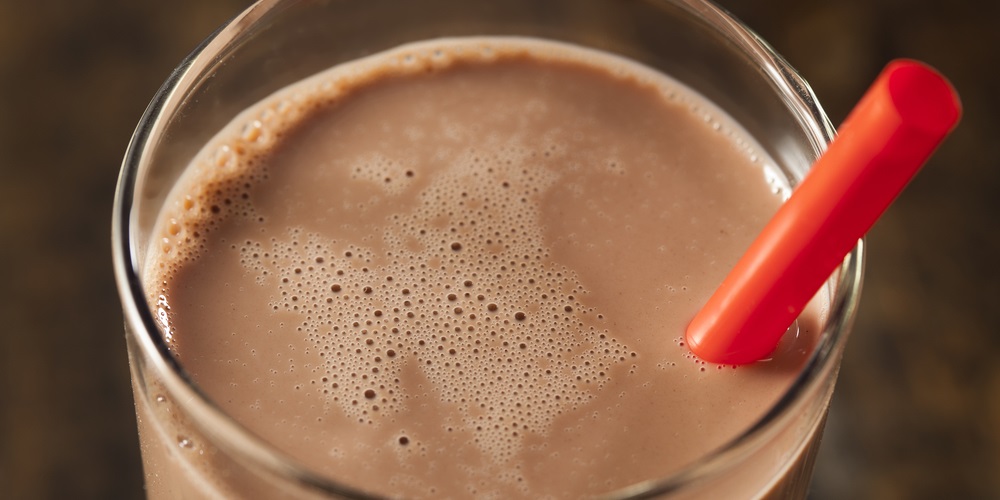Chocolate milk in a glass with a red straw